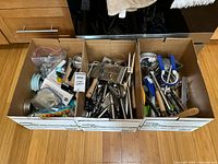 Three boxes filled with assorted utensils