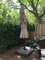 Closed cantilever umbrella mounted on square base in garden