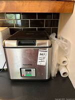 Front view of Sous Vide Supreme SVS10LS with attached lot sticker and bag rolls at right