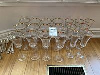 Group of clear glass stemware with gold rims displayed on floor