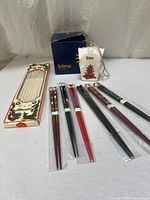 Full lot showing seven chopstick pairs, boxed bamboo chopstick set, Kitras ornament and box