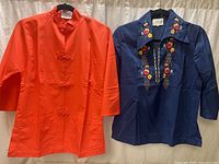 Front view of both tunics hung side by side