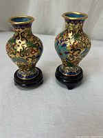 Front view of both cloisonné vases on stands