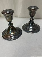 Both candlesticks side by side showing overall form and patina
