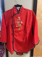 Front view of red embroidered jacket showing overall design and colour