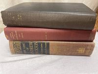 Three books stacked showing spine titles and cloth colors