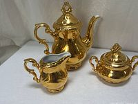 Full view of teapot, creamer, sugar bowl showing gold luster finish