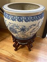 Overall view of porcelain fishbowl on wood stand