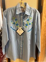 Front view of light blue Western shirt with embroidery and tags