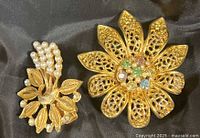 Both brooches side by side on fabric