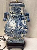 Full view of porcelain vase lamp on wood base showing blue floral and dragon motifs