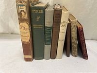 Front view of all eight vintage hardcover books showing spine titles and colors
