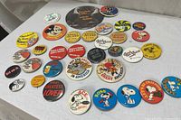 Full assortment of pinback buttons laid out showing variety and condition