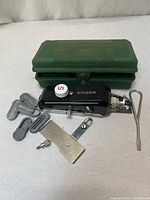 All components laid out: attachment, case, templates, plate, bracket, tool