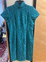 Full front view of teal cheongsam dress on hanger