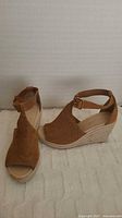 Side view of wedge sandal showing suede upper, jute-wrapped heel