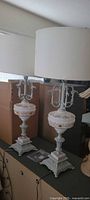 Both matching vintage table lamps with shades on surface