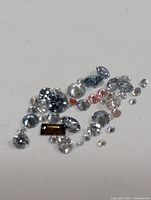 Close view of assorted loose lab-grown diamonds showing colours and cuts