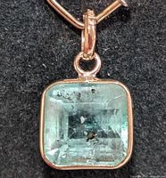 Front view of emerald pendant showing stone clarity and gold bezel
