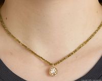 Necklace worn on model neck showing full strand and pendant