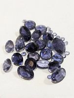 Group of faceted Iolite gemstones laid out to show color and cuts