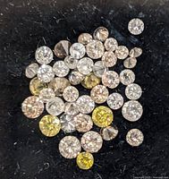 Loose mixed color diamonds on dark background