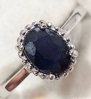 Close view of sapphire and halo detail on silver ring