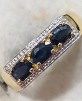 Top view showing three sapphires and clear stone border