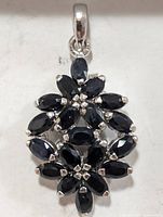 Front view showing floral cluster of marquise sapphires set in silver