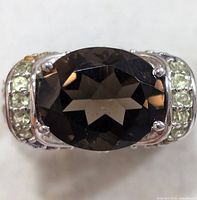 Top view showing oval smoky quartz centre stone and light green accent stones