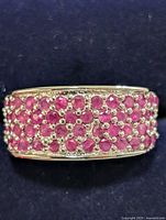 Front view of silver band densely set with round rubies