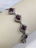 Close view of square halo link with ruby-coloured CZ center and clear CZ border