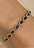Bracelet on wrist showing garnet and CZ design