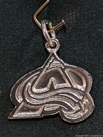 Front view of silver-tone Colorado Avalanche logo pendant showing design details