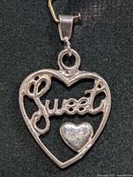Front view of heart pendant showing "Sweet" script and small heart accent