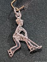 Front view of silver hockey player pendant showing overall design