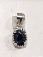 Front view of silver pendant showcasing oval sapphire