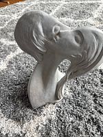 Full view of sculpture showing kissing faces form