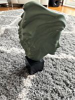 Front left profile of green bust on marble base