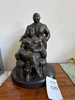 Front view of bronze couple sculpture on marble base with MaxSold tag visible