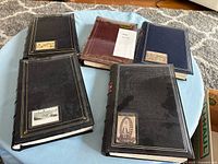 Five postcard albums on surface showing exterior covers