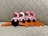 all four ostrich-shaped wooden hangers lined on sofa