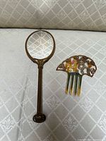 Front view of mirror and comb on fabric surface