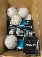 Open box showing multiple Dudley Thunder softballs, some boxed, some in plastic