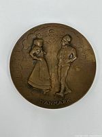 Front view showing embossed figures and "DANMARK" text