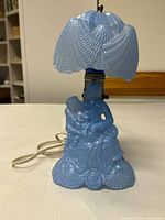 Full view of blue glass lamp with shade, base and cord