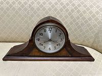 Front view of wooden mantel clock showing dial and case shape