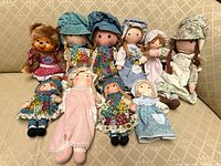 Group view of all ten soft dolls arranged on sofa