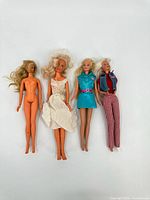 Group shot of four Barbie dolls with various outfits