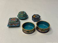 Five small blue decorative boxes displayed together
